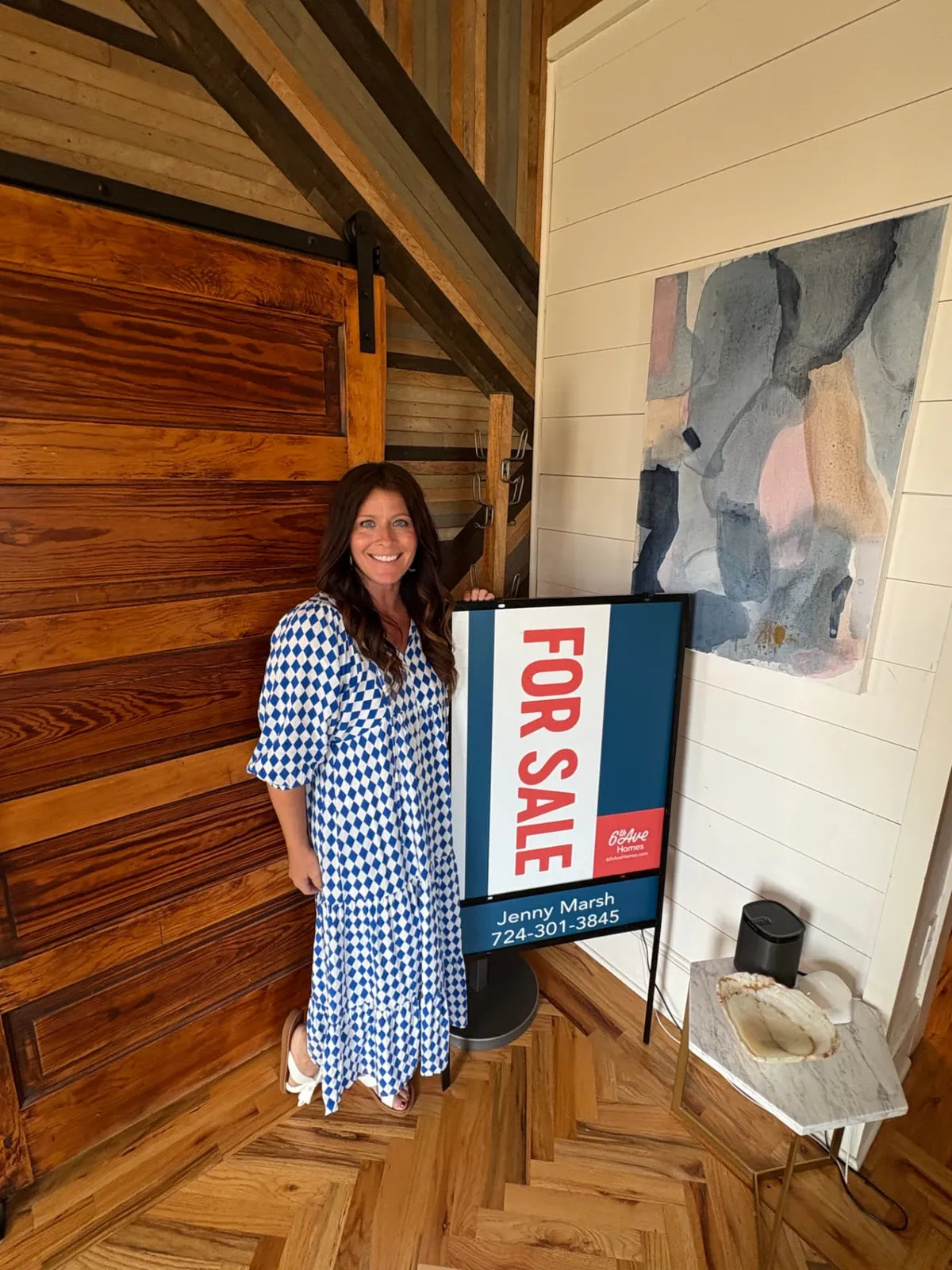 Jenny Marsh beside her 6th Ave Homes For Sale sign inside a listing