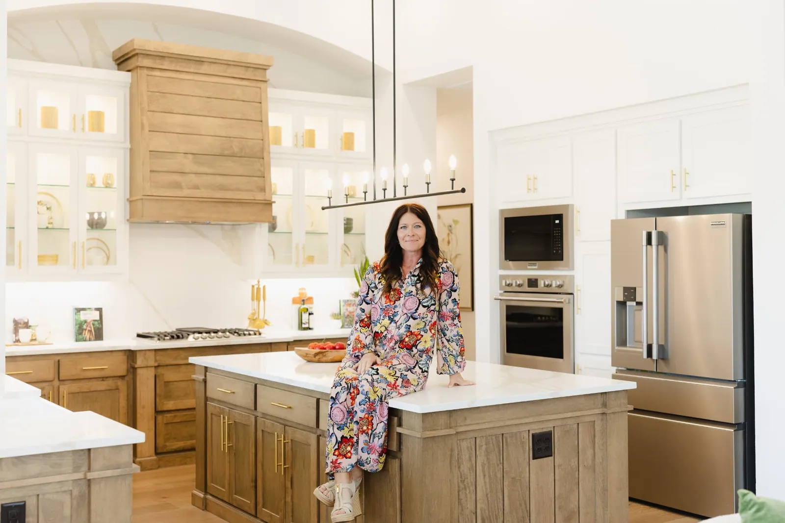 Jenny Marsh seated on a kitchen island, laughing